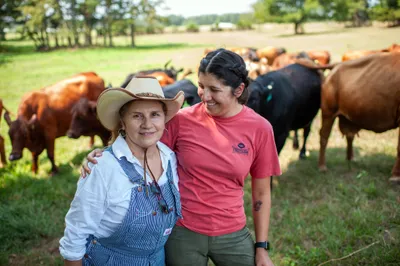 Maria Contreras, left, and her daughter, Lorena Jenkins, stand for a portrait after feeding cattle at their family farm in Blevins, Ark. on Sept. 7, 2023. Photo by Rory Doyle.